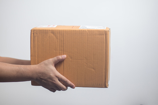 Hand holding a parcel box on a white background