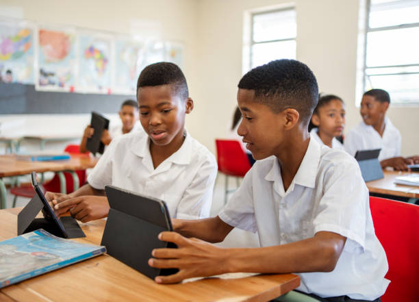 School kids in class using digital tablets