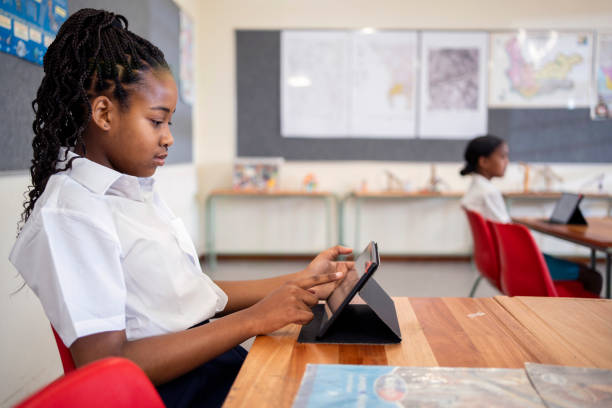 istock Schoolgirl sitting in classroom and using a digital tablet 1770689855