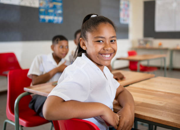 istock Schoolgirl looking at camera and smiling in classroom 1770691026