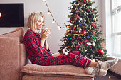 woman with coffee cup sit on couch in house indoors with christmas x-mas atmosphere decoration
