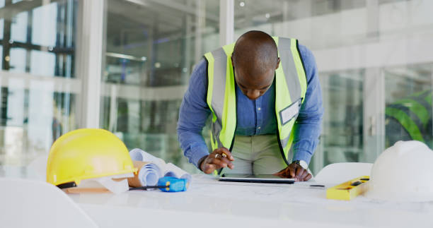 istock Black man, tablet and check floor plan for construction or architect working in office, contractor and maintenance. Review digital blueprint for architecture project, productivity and design software 1770711369