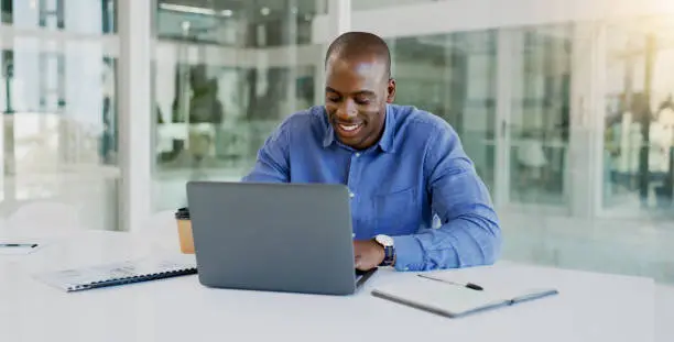 Photo of Business man, laptop and happy in office for finance, budget report and revenue proposal, taxes review or bookkeeping. Professional african worker on computer for online accounting, audit or planning