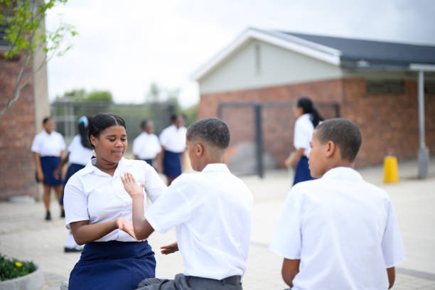 istock Schoolgirl and boy sit playing clapping game during recess 1770718802