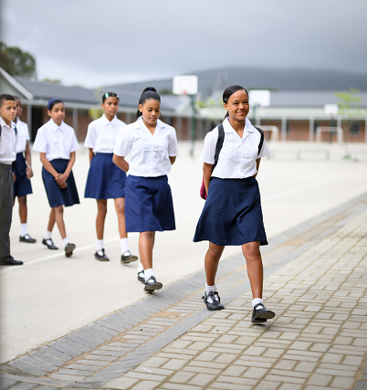 Schoolgirls walk to class in a row