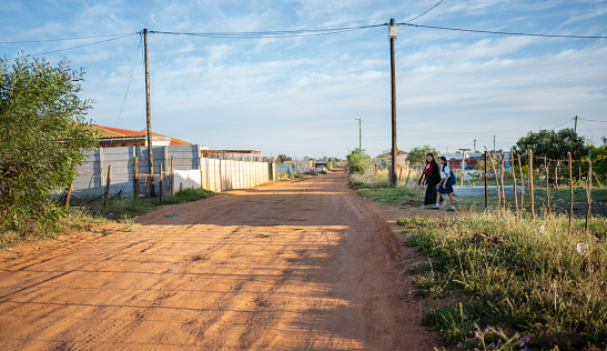 View of a road in small town with a mother taking her daughter to school from home