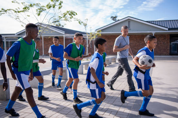 istock School boys soccer team going on training ground with coach 1770731635