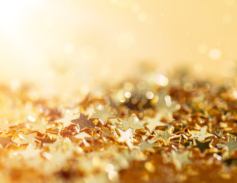 Golden Christmas Stars and Defocused Bokeh. Abstract Light Ornament Decoration.