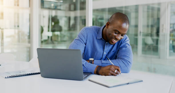 istock Business man, writing and planning on computer for financial career notes, information and reminder in office. Professional african accountant on laptop and notebook for happy ideas and brainstorming 1770745124