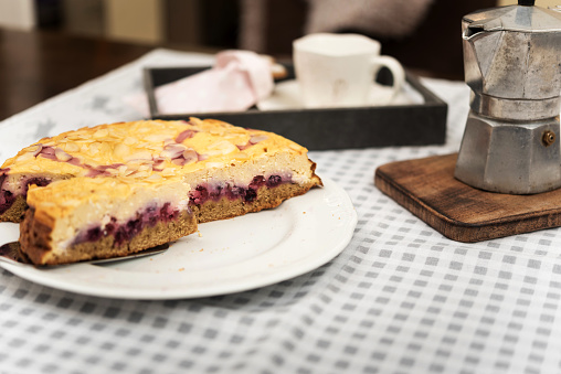 A slice of delicious blueberry cheesecake with fresh blueberries on a rustic wood table top.