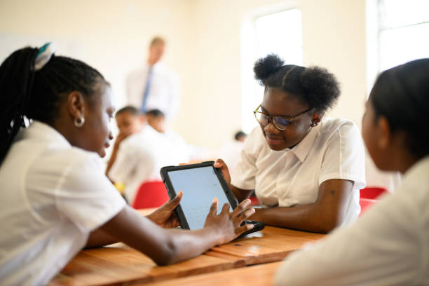 istock Over shoulder view black schoolgirls using digital tablet together in class 1770759085