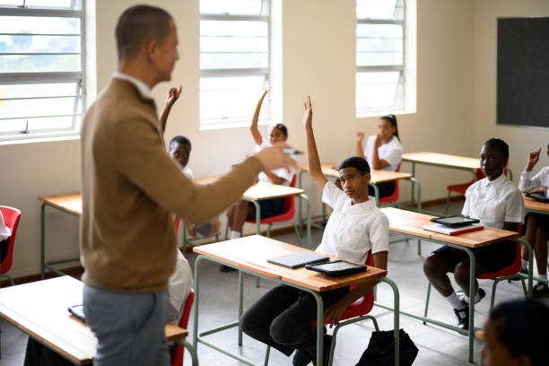 istock Schoolchildren in class with hands raised 1770760288