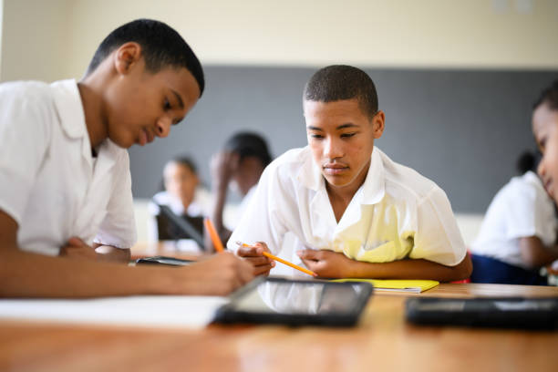 istock Teenage boys concentrate working out solution together in class 1770760864