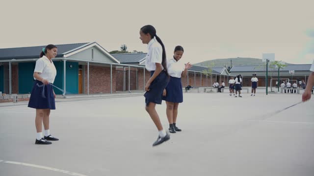 Elementary students jumping rope in a schoolyard during lunch break