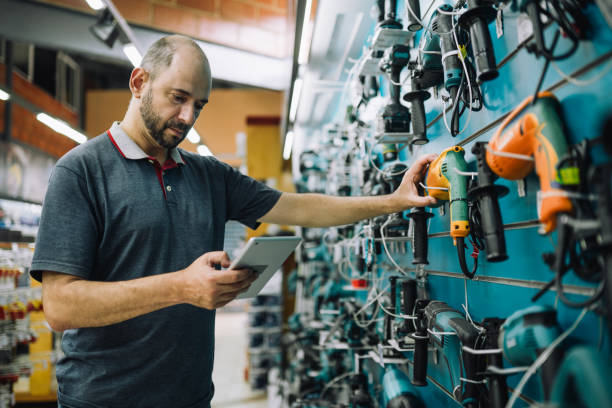 Male owner of a hardware store taking an inventory using a digital tablet