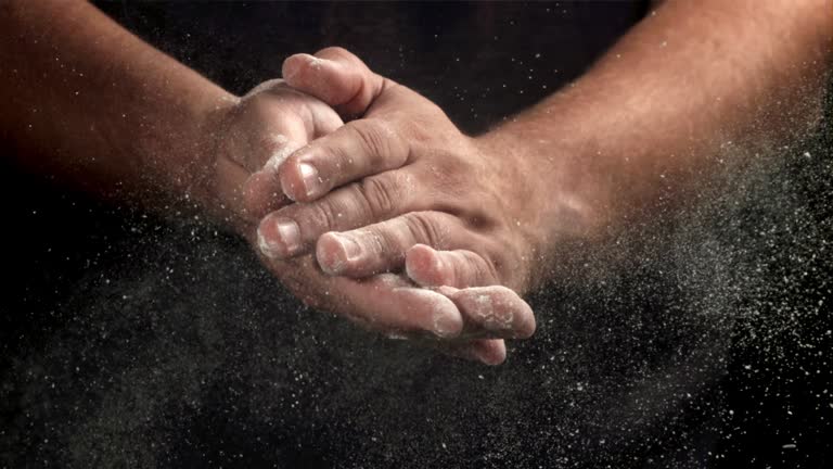 The cook claps his hands with flour. Filmed on a high-speed camera at 1000 fps.