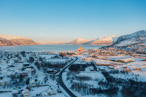 vista aérea do dramático pôr do sol de inverno sobre a cidade cênica por fiorde com carros dirigindo na estrada na noruega - more objects - fotografias e filmes do acervo
