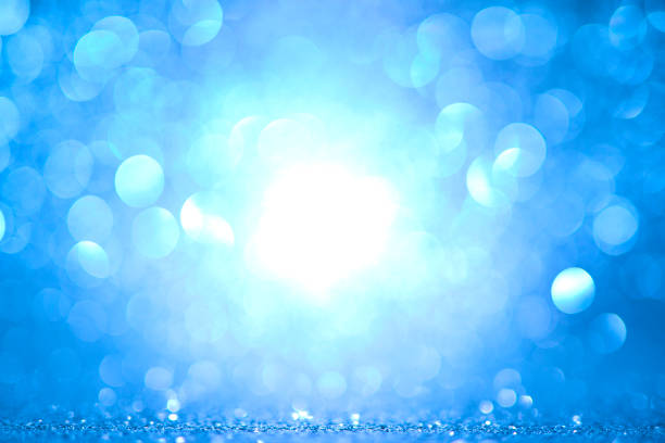 Defocused golden sequin light. Fancy blue glitter sparkle background. Studio shooting of a creative bright silver color background. It is textured color gradient. There are no text and no people, and have copy space for design. Its Suitable for commercial use. Christmas, New Year, Diwali festive celebrations themed backgrounds, wallpapers, templates for greeting cards, banners and posters and wrapping paper is apt.