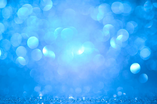 Defocused golden sequin light. Fancy blue glitter sparkle background. Studio shooting of a creative bright silver color background. It is textured color gradient. There are no text and no people, and have copy space for design. Its Suitable for commercial use. Christmas, New Year, Diwali festive celebrations themed backgrounds, wallpapers, templates for greeting cards, banners and posters and wrapping paper is apt.