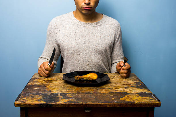 istock Young man having a chicken drumstick to eat 177081975