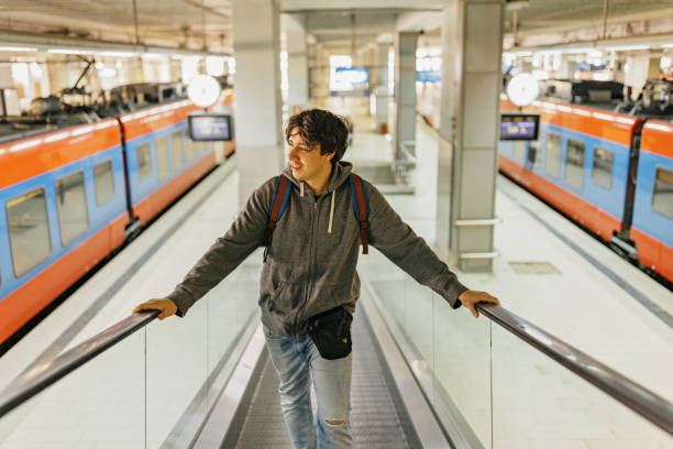 istock One young man on the moving walkway at train station 1770828519