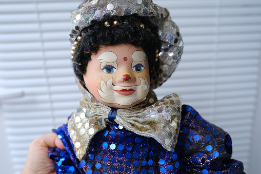 clown in blue shiny suit, abandonment, loss and resilience, source of companionship and emotions, potential of clown doll as therapeutic tool