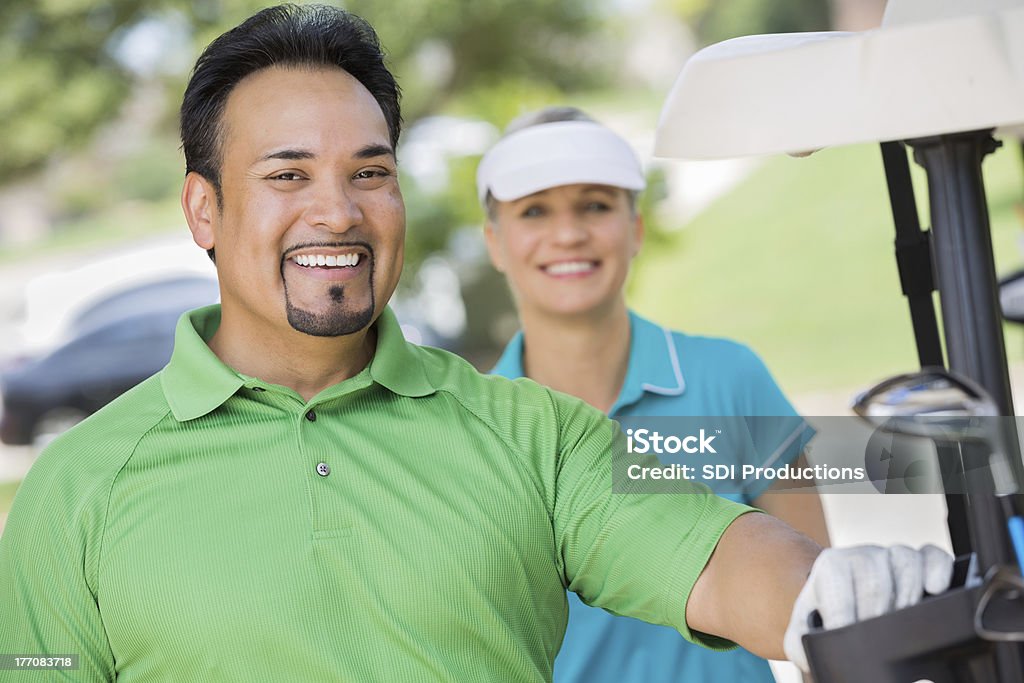 Hombre hispano apoyarse en carrito antes de jugar juego de golf - Foto de stock de Aire libre libre de derechos