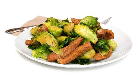 Stir fried brussel sprout and pork cut dish isolate white
