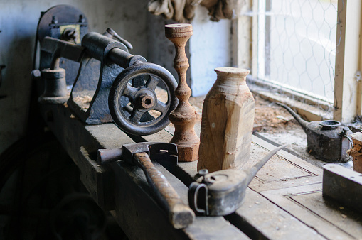 Old fashioned wood turning lathe and tools in a garage