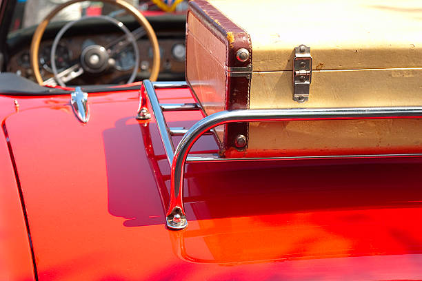 Luggage on a luggage rack. Vintage red sports car.