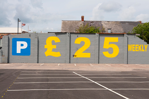 Wall painted with an advertisement for car parking for £25 weekly.