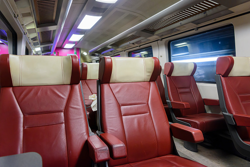 Red leather seats in the first class carriage of a train in the Netherlands.