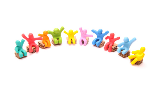 10 colorful group of cheerful plasticine people arranged in a half circle sitting on paper chairs - isolated on white