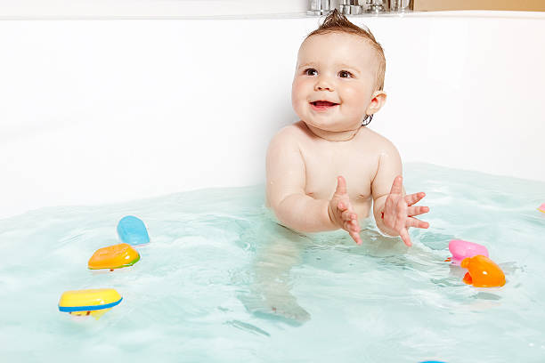 cute bebê bater palmas mãos enquanto estiver a tomar um banho - bath toy imagens e fotografias de stock