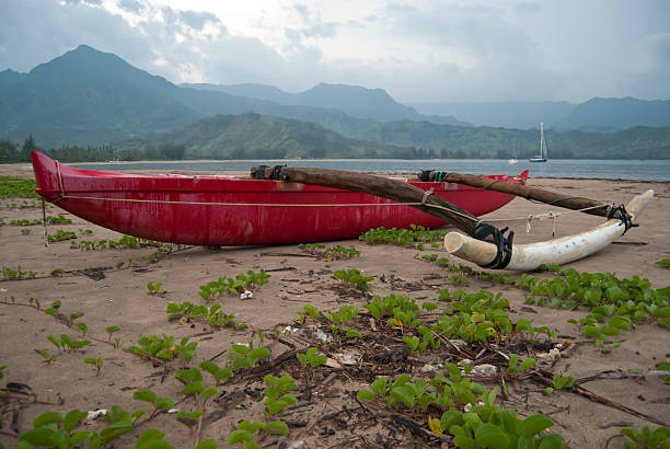 Red Hawaian Canoe Red Hawaian Canoe on the beach outrigger stock pictures, royalty-free photos & images