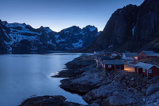sunset over a group of traditional fishermen's houses, nowadays mostly used as accommodation for tourists, on the Lofoten Islands in Norway at dusk; Reine, Norway