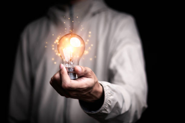 istock Businessman holding a light bulb creates new ideas. Innovation. Brainstorming. Solutions. And inspiration. Imagination. Creativity. Problem solving. Solution removing obstacles to success in business. 1770922663