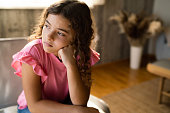 Sad teenage girl sitting at home