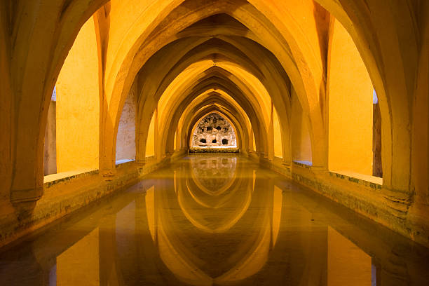 Baths in the Royal Alcazar of Seville Reflected arches in the Baths of Lady Maria de Padilla (Banos de dona Maria de Padilla) in the Royal Alcazar, Seville, Spain. alcazar seville stock pictures, royalty-free photos & images