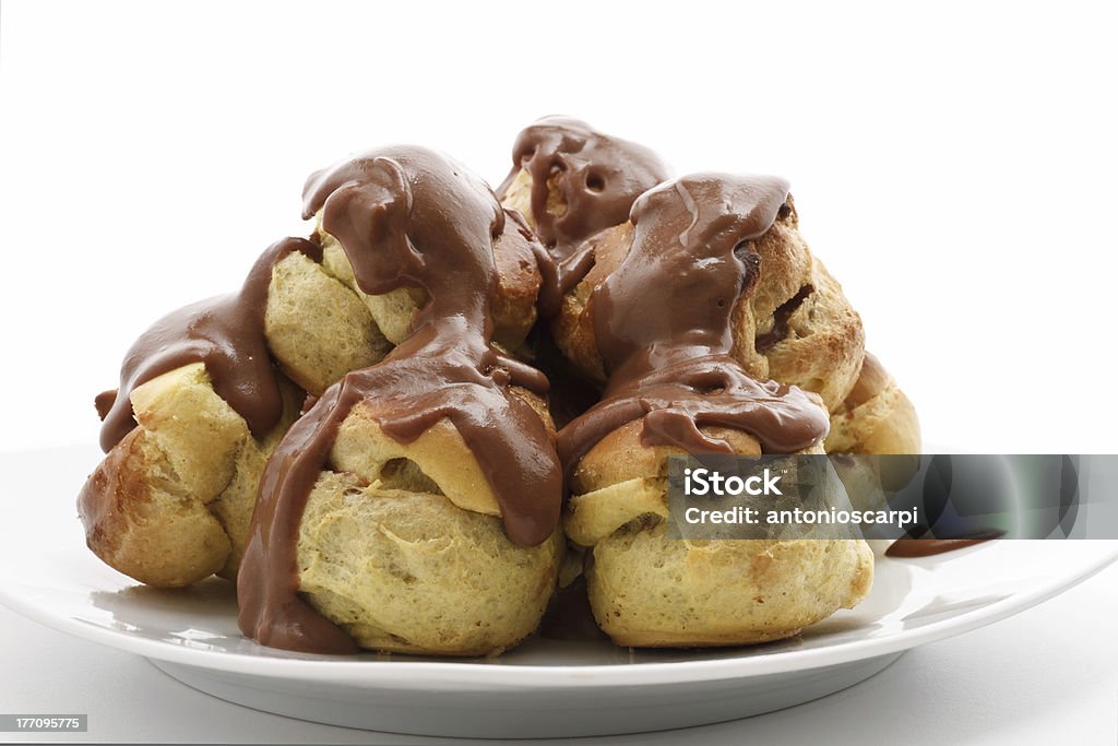 dessert profiteroles detail of profiteroles with chocolate sauce over white background Baked Pastry Item Stock Photo