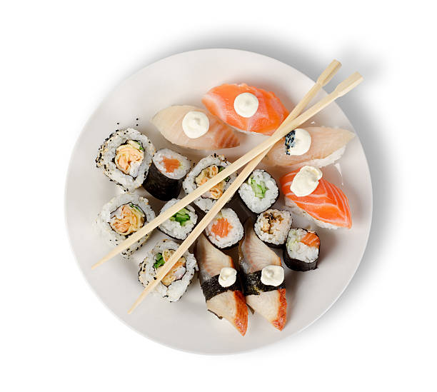 Sushi and chopsticks on a white plate Sushi and rolls in a plate with sticks isolated on a white background. Clipping path sushi plate stock pictures, royalty-free photos & images