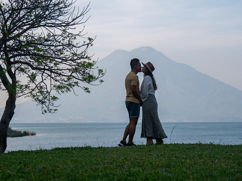 Couple on the lakeshore, volcano view, Guatemala