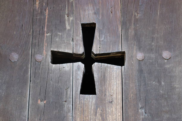 Carved cross on wooden background
