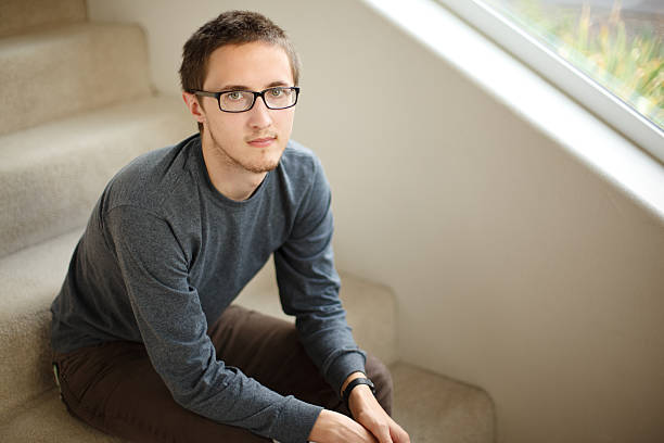 Young man sitting on stairs stock photo