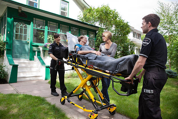 Senior Woman on Ambulance Stretcher Senior woman being taken to hospital, family member at side stretcher stock pictures, royalty-free photos & images