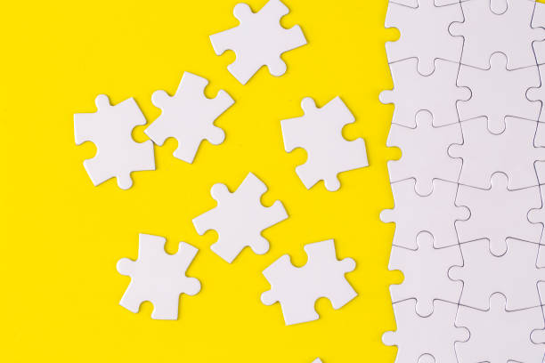 istock Missing jigsaw puzzle pieces. Business concept. Fragment of a folded white jigsaw puzzle and a pile of uncombed puzzle elements against 1771009005