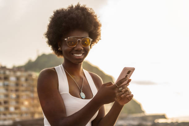 istock Stylish african woman using phone outdoors during sunset 1771026287