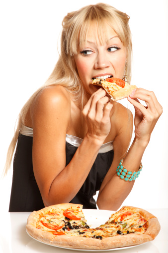 Cheerful blonde fashion woman is eating pizza and glancing  on white background