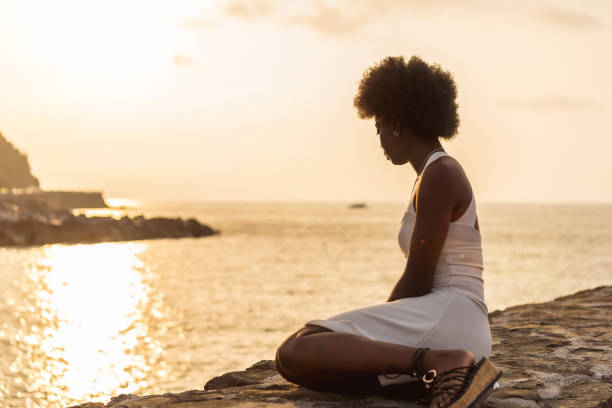 Afro woman gazing the ocean during sunset
