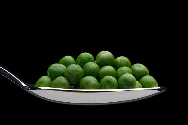 Guisantes en una cuchara - foto de stock